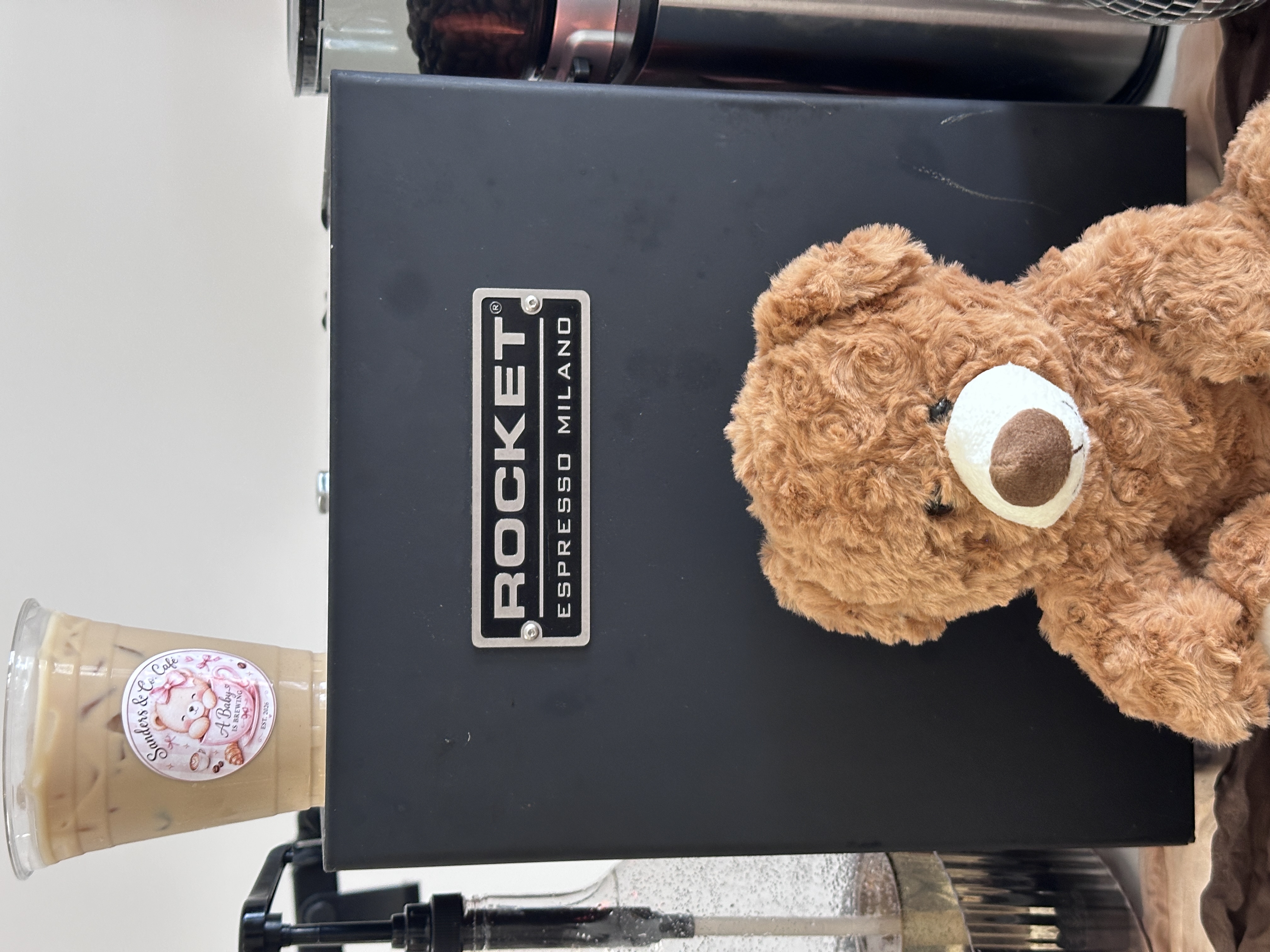 Iced matcha latte with rainbow sprinkle topping next to teddy bear at Tee Coffee Studio Atlanta baby shower event
