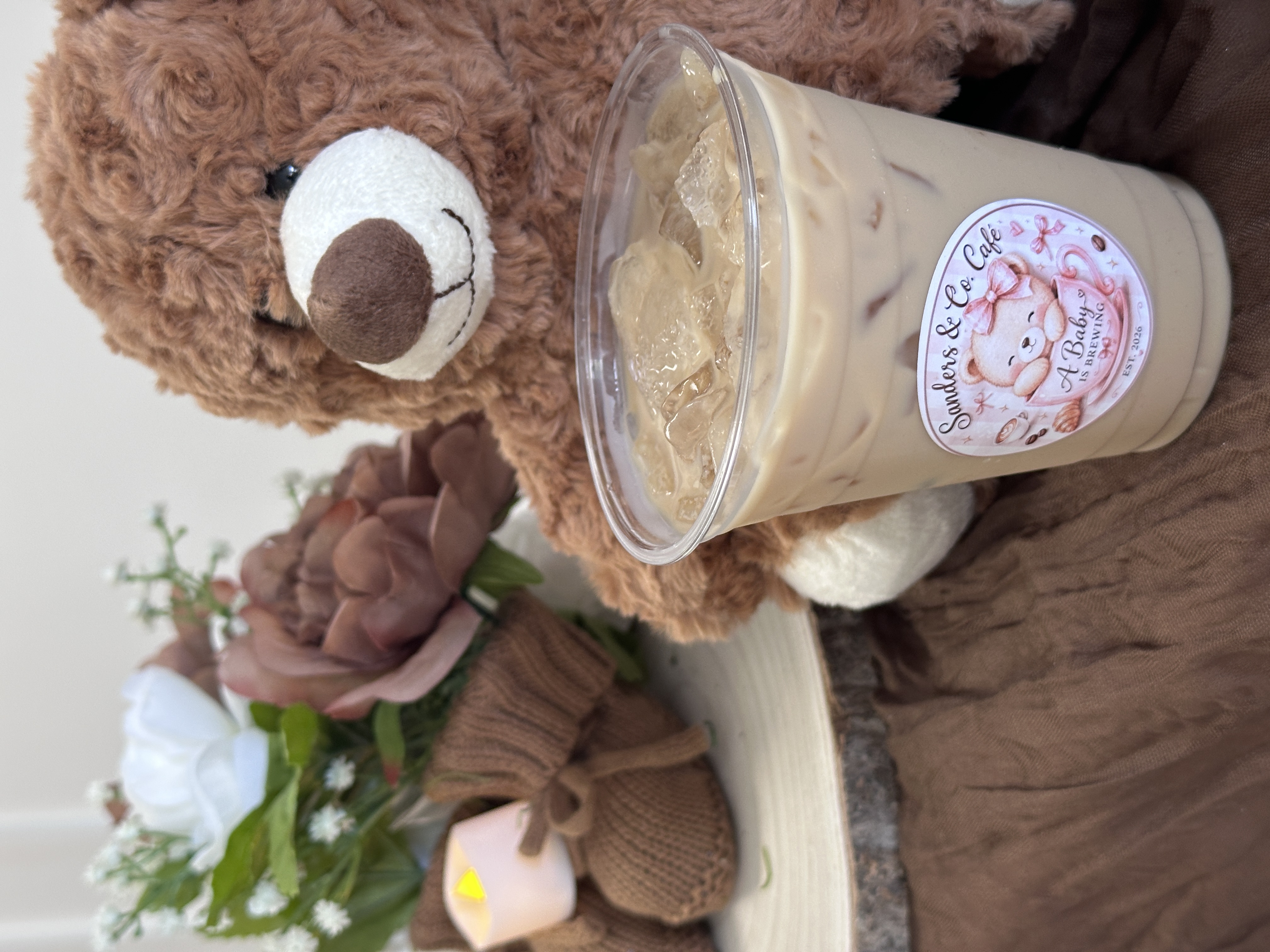 Teddy bear sitting in front of Rocket Espresso Milano machine with branded baby shower latte at Tee Coffee Studio Atlanta event
