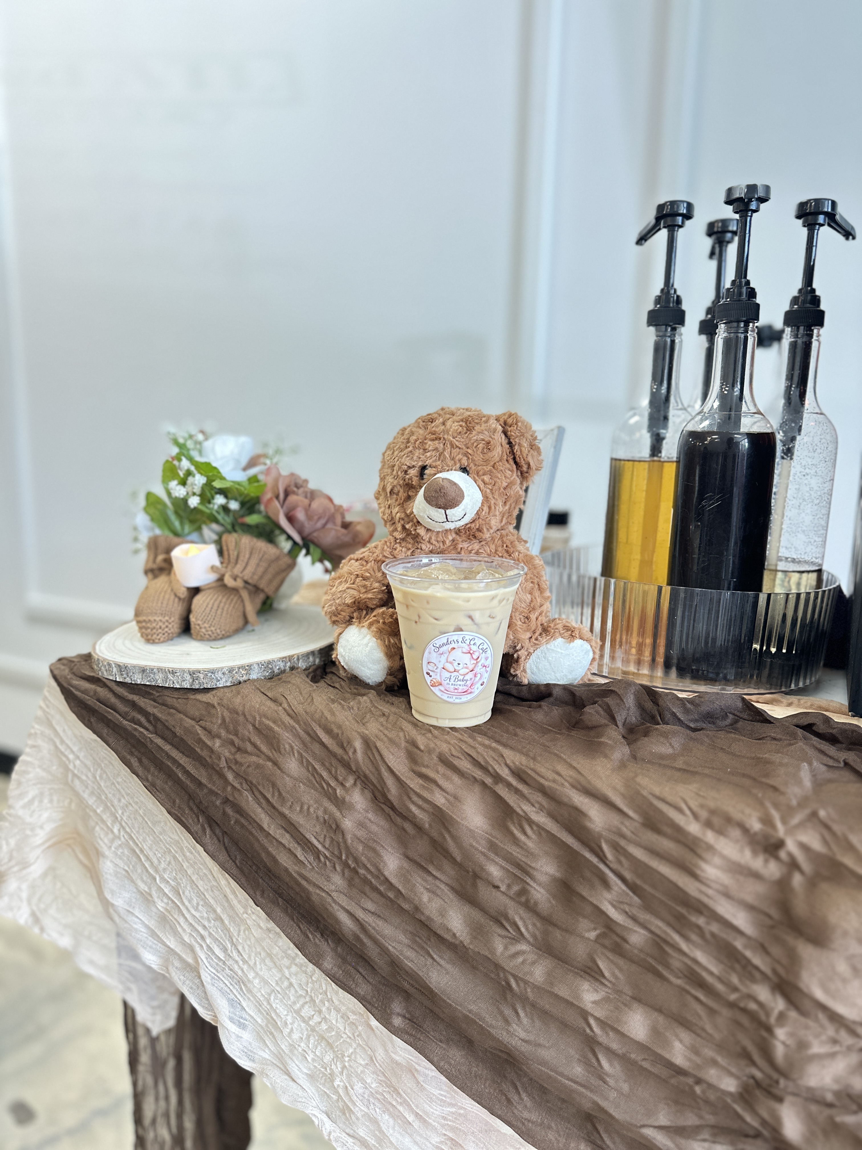 Tee Coffee Studio baby shower espresso bar with teddy bear mascot, specialty syrups, and branded custom latte cups at Atlanta celebration