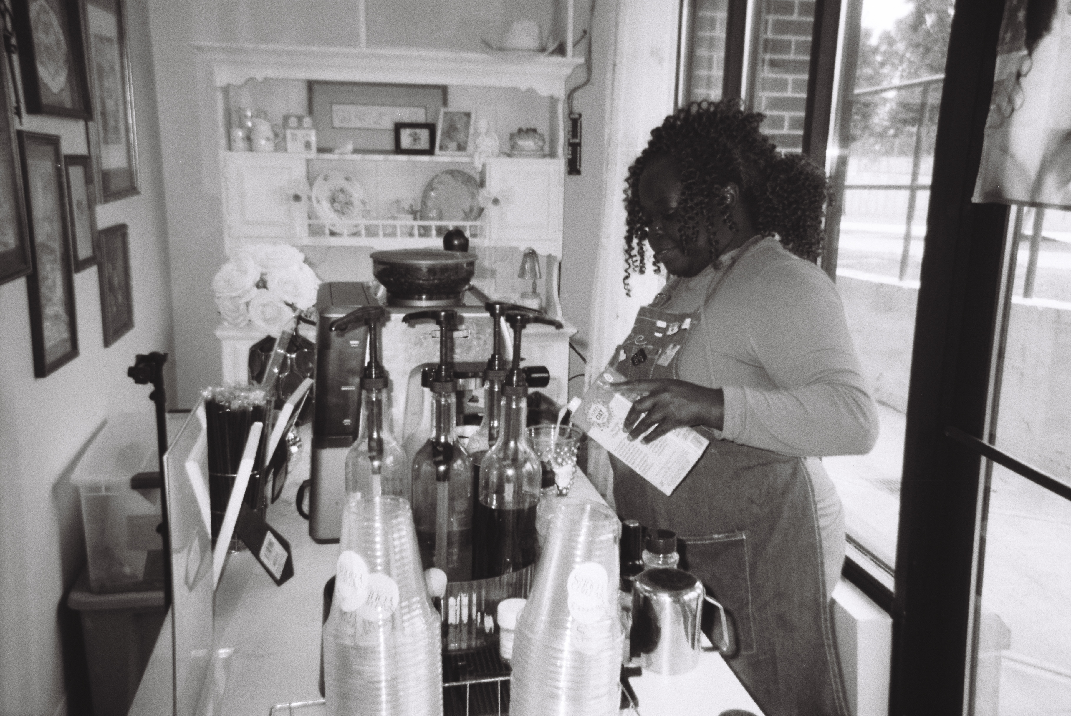 Black and white photo of Tee George working behind specialty espresso bar at Atlanta event