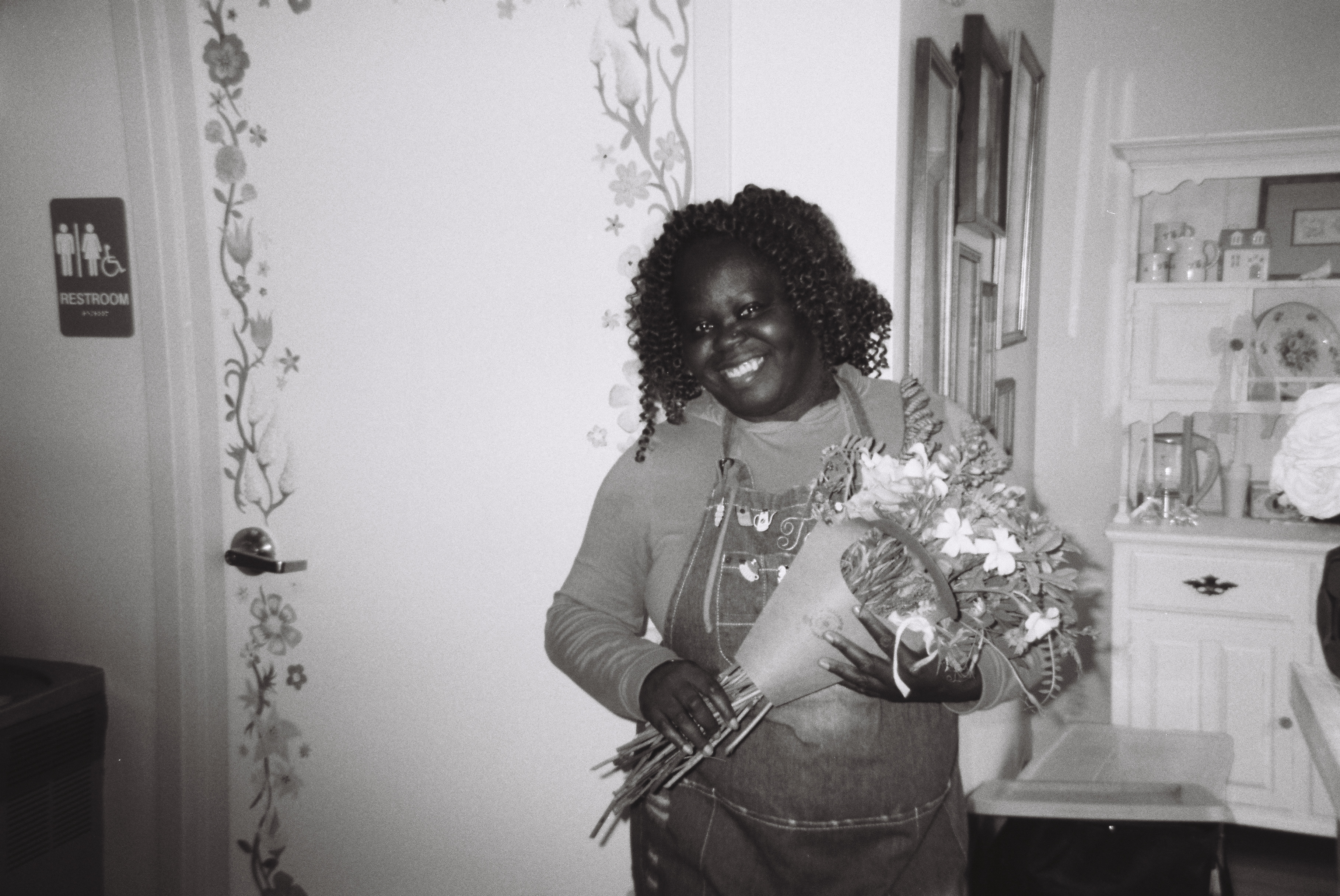 Black and white photo of Tee George holding bouquet of flowers gifted by grateful Atlanta event client