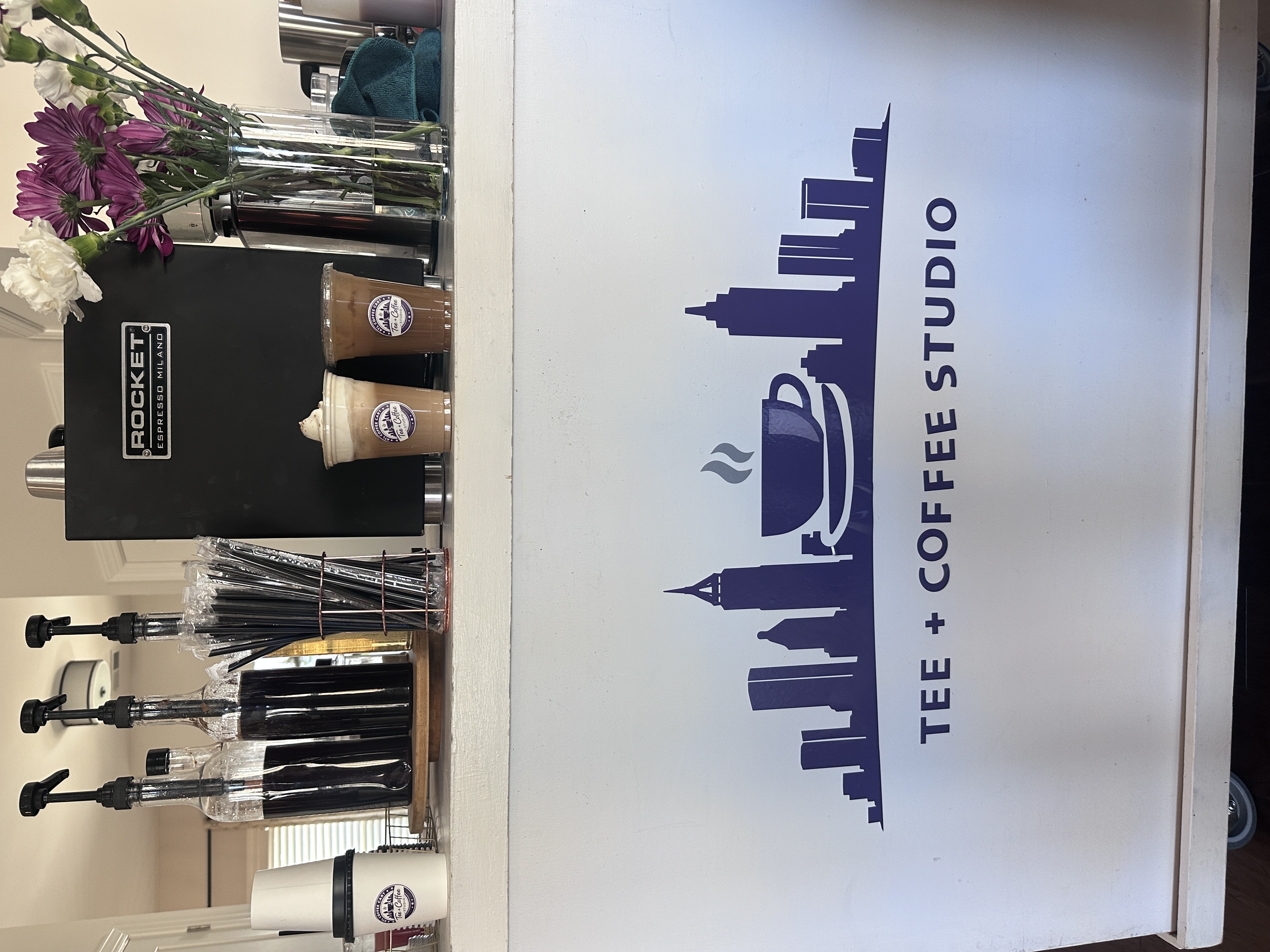 Tee Coffee Studio branded cart closeup with iced lattes, Rocket espresso machine, and fresh flowers ready for Atlanta event