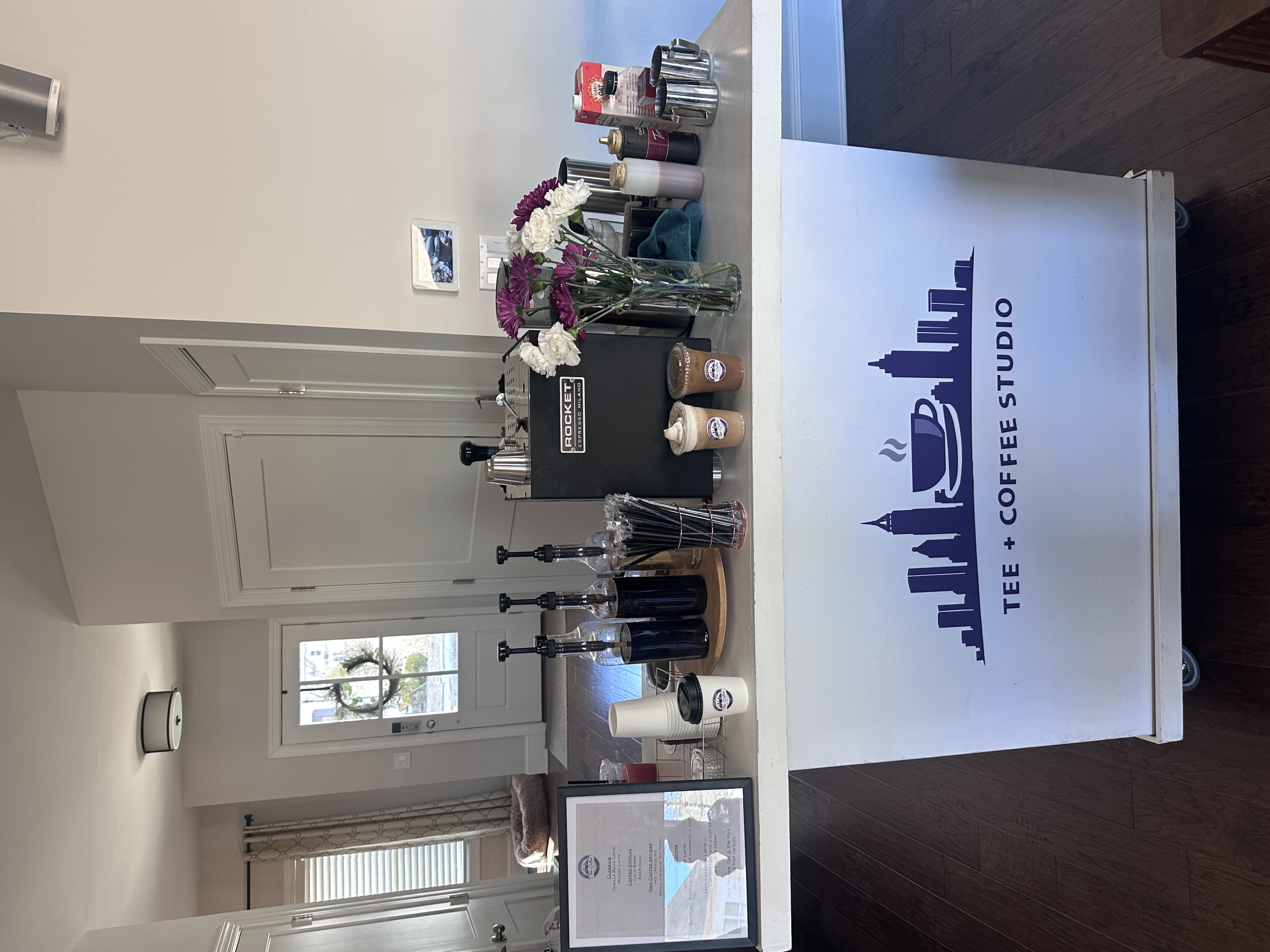 Tee Coffee Studio branded mobile espresso cart with Rocket espresso machine, specialty syrups, and fresh flowers at Atlanta private event