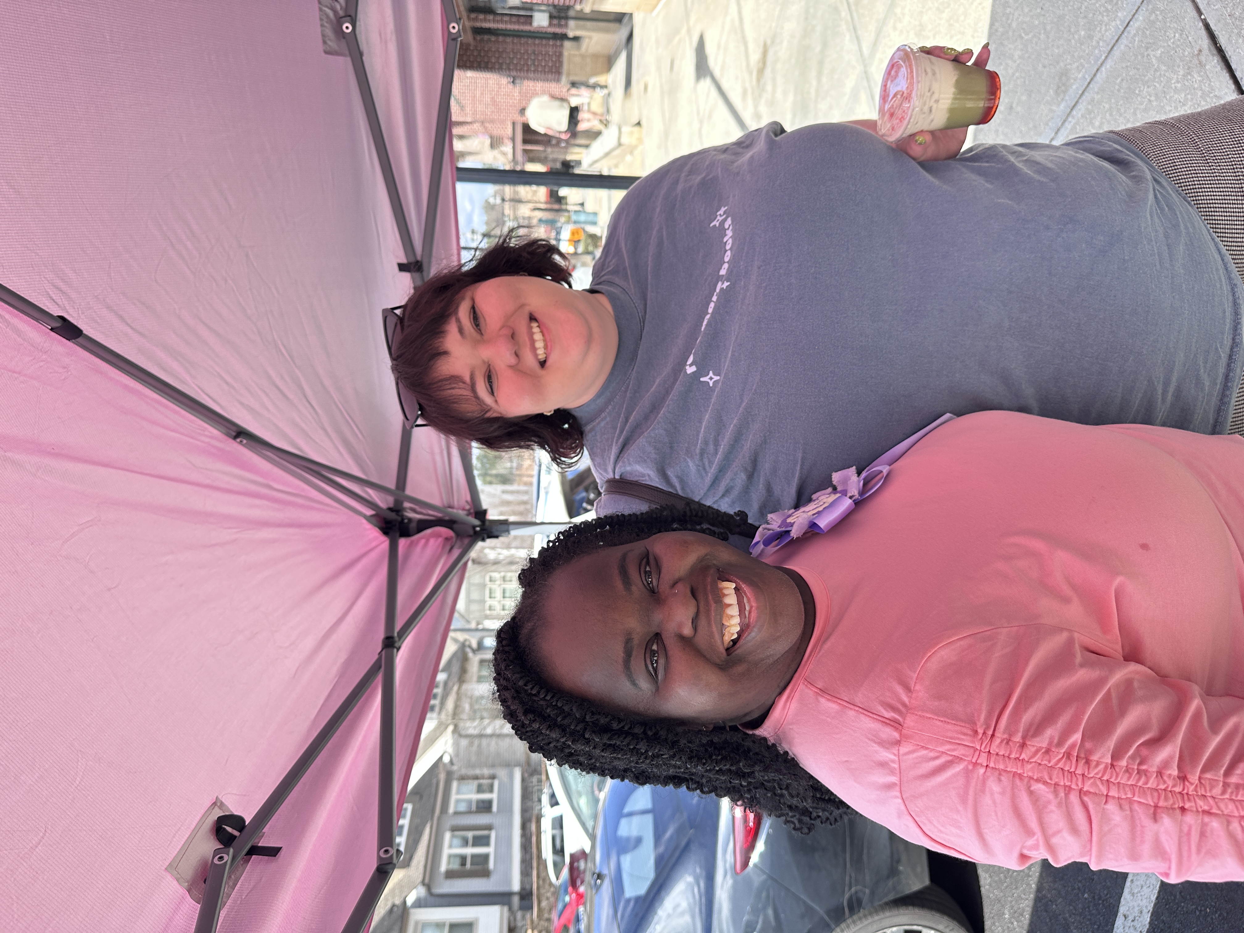 Tee George with happy guest at Atlanta community birthday pop-up event under pink tent