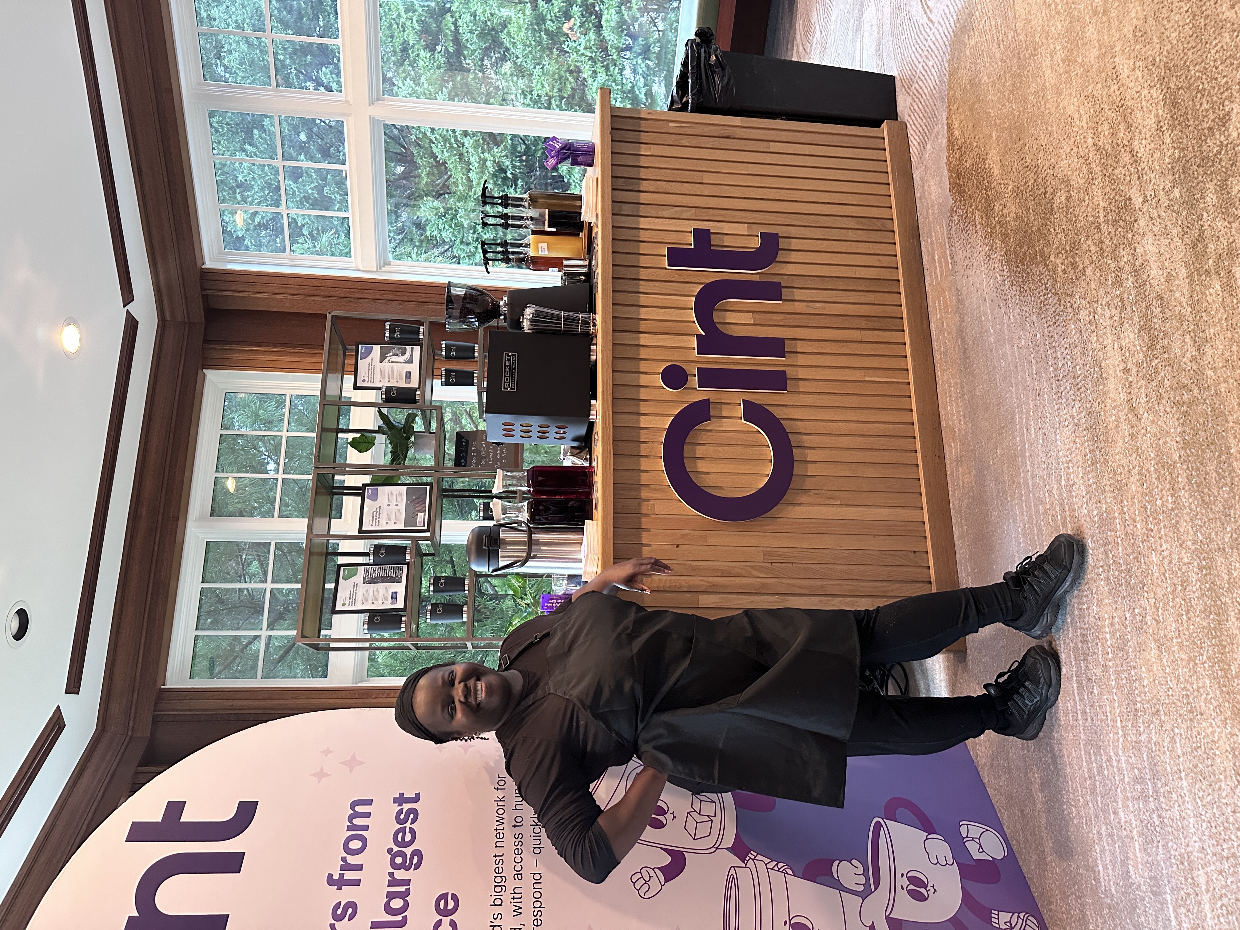 Tee George standing at custom branded corporate coffee bar at Atlanta conference event