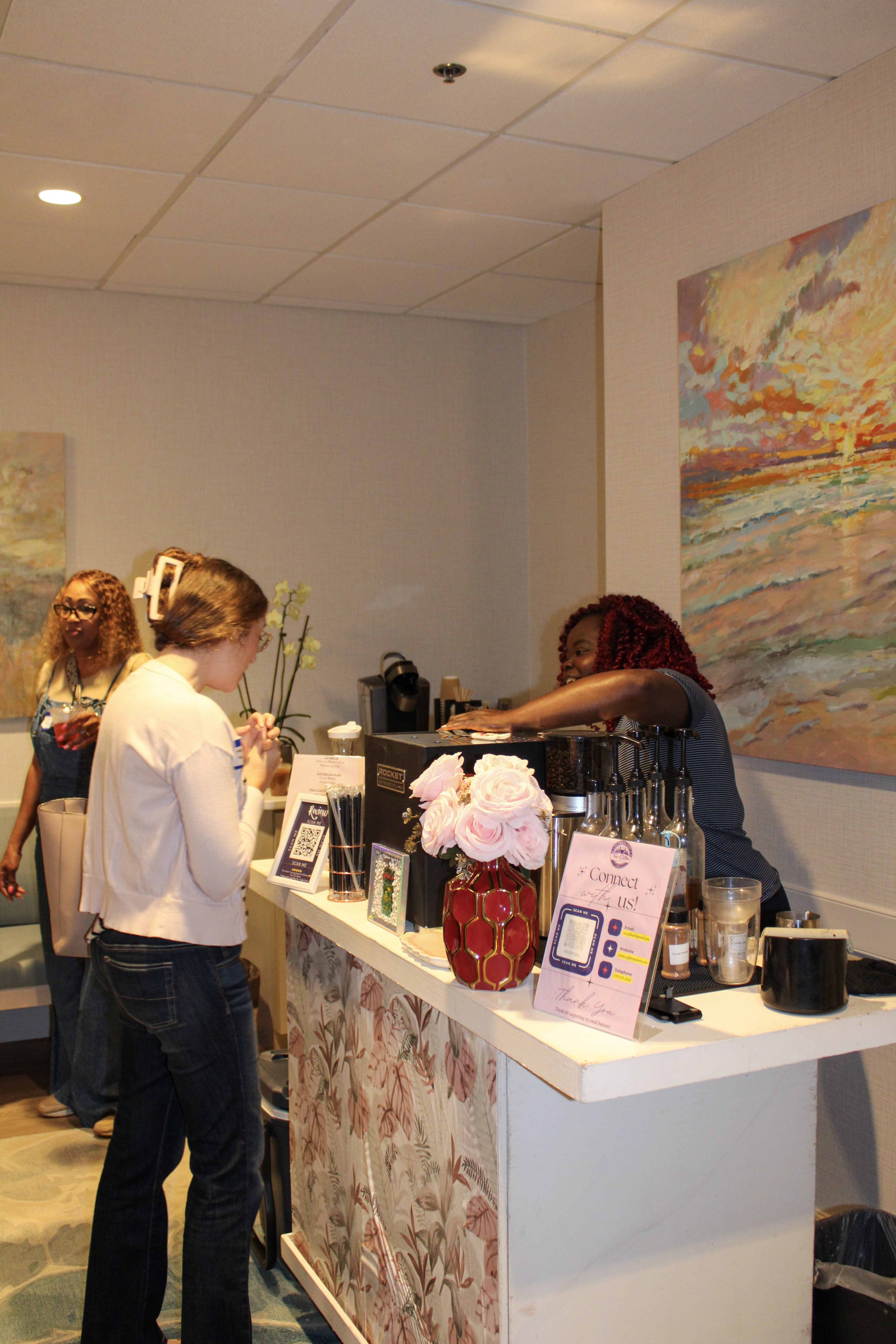 Wide view of the Tee Coffee Studio espresso bar setup in a professional Atlanta office space with art on the walls