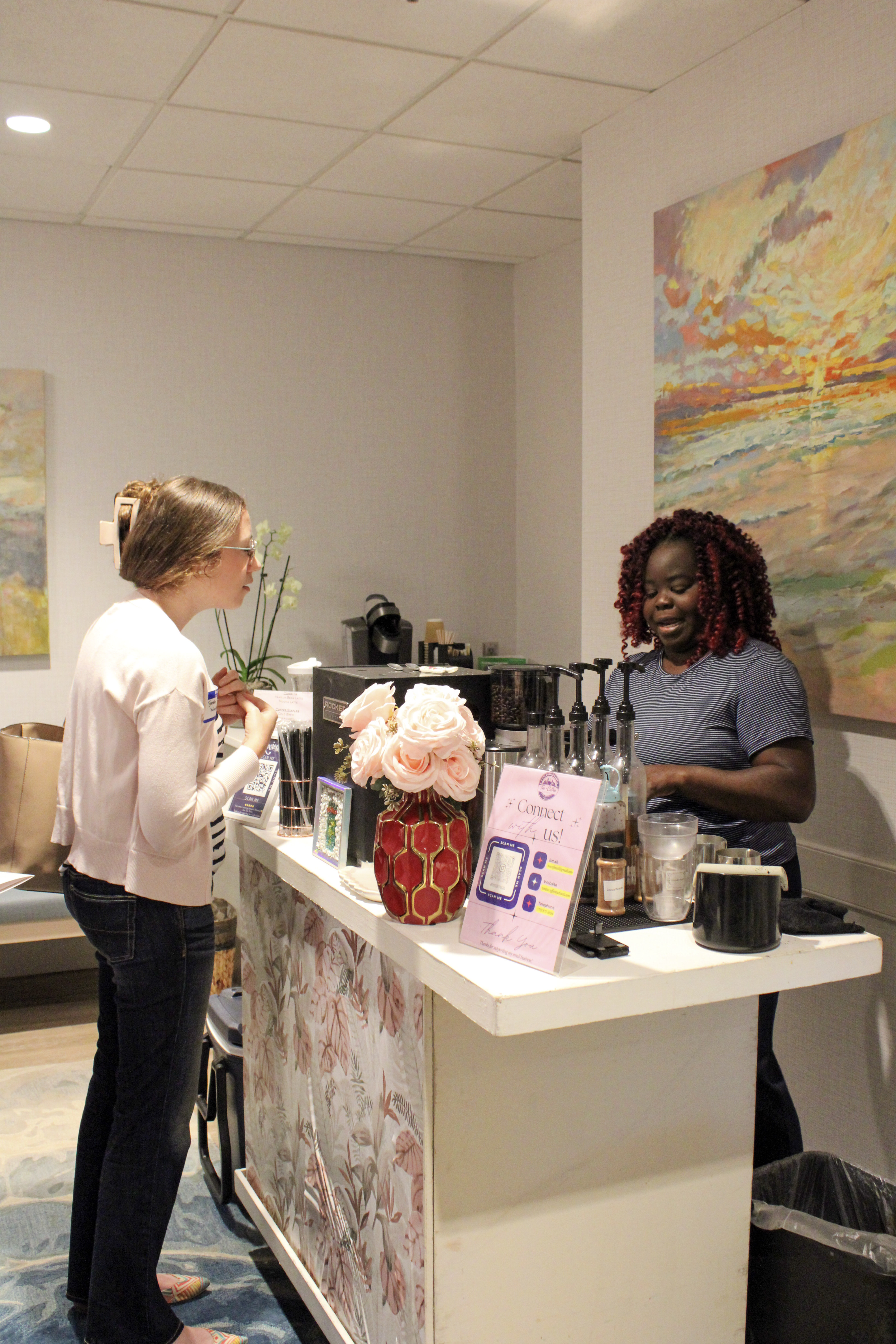 Tee George consulting with a guest at the espresso bar during a corporate event at an Atlanta office