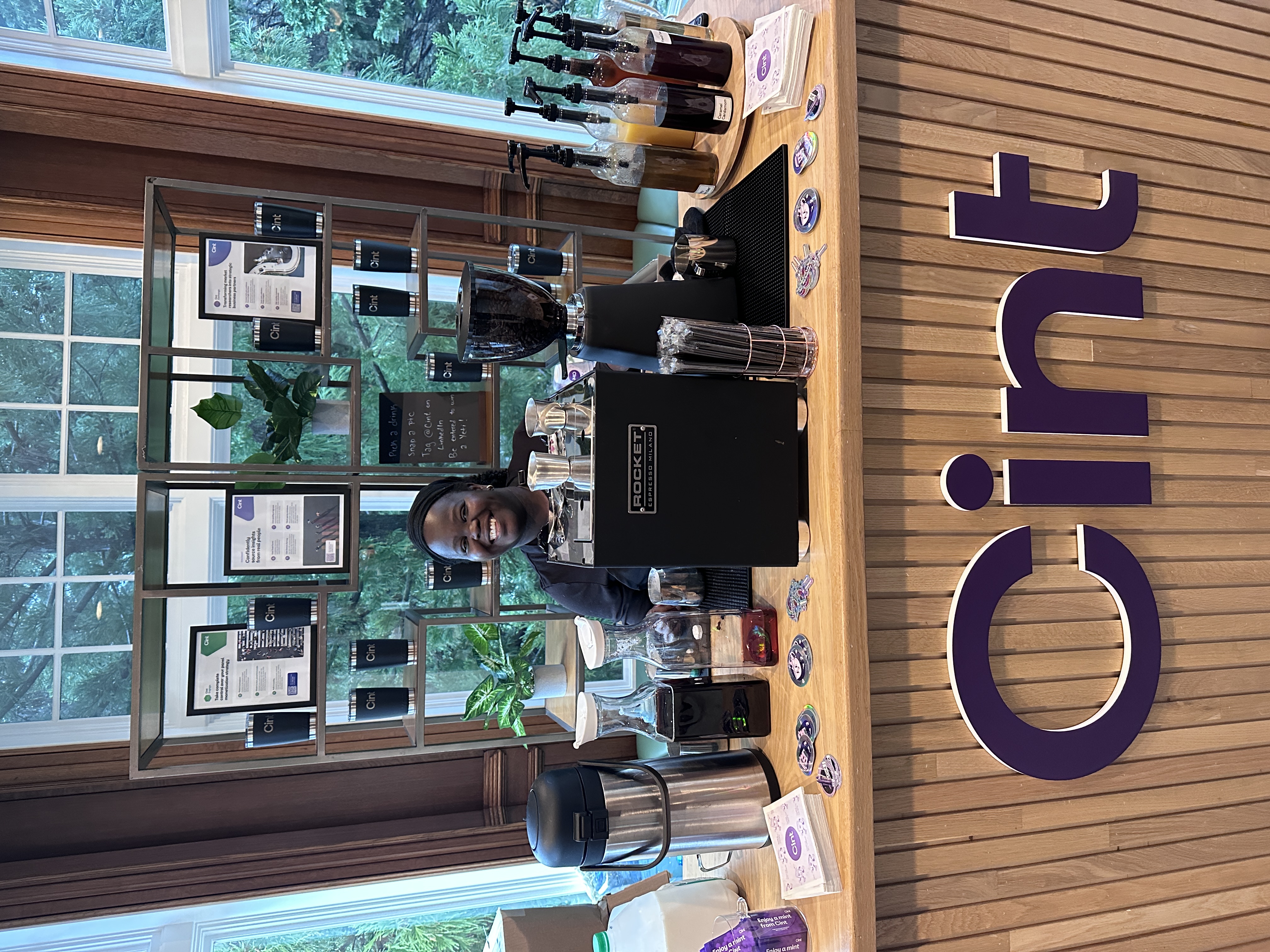 Tee George smiling behind Tee Coffee Studio branded espresso bar at Atlanta corporate conference event