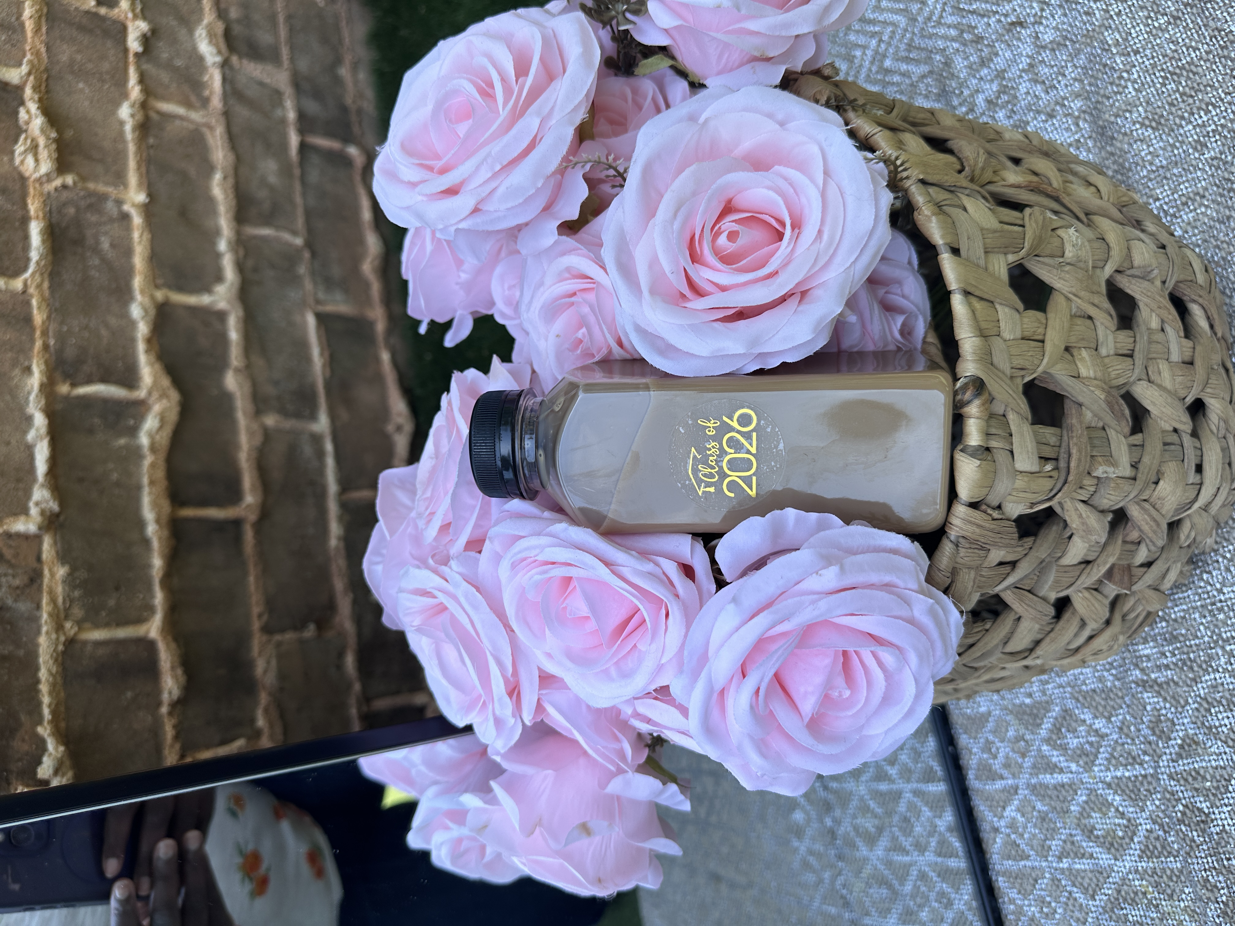 Custom Class of 2026 branded bottled latte nestled in pink roses at Atlanta graduation celebration