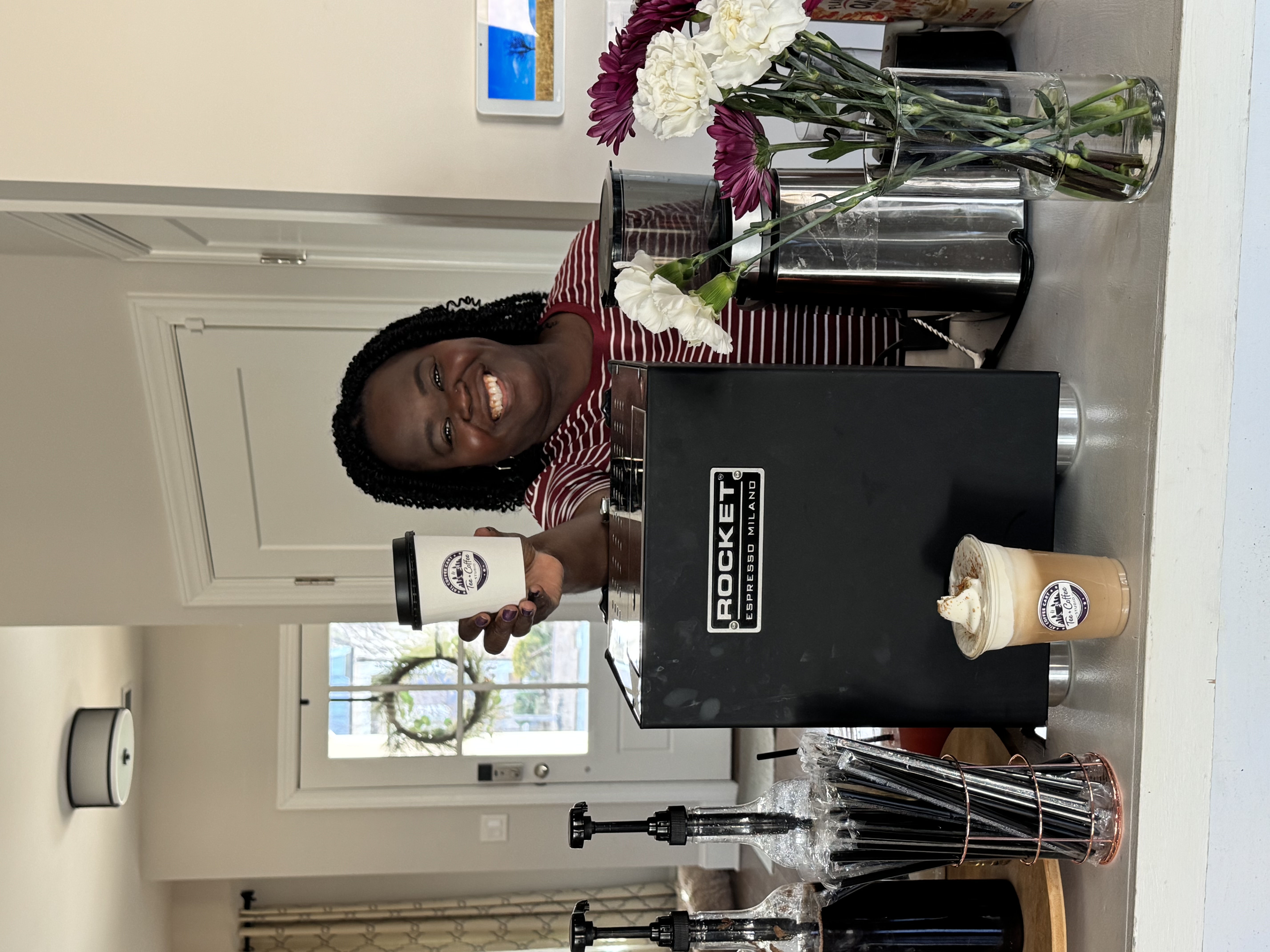 Tee George smiling behind Tee Coffee Studio cart with Rocket espresso machine and fresh flowers at Atlanta private event