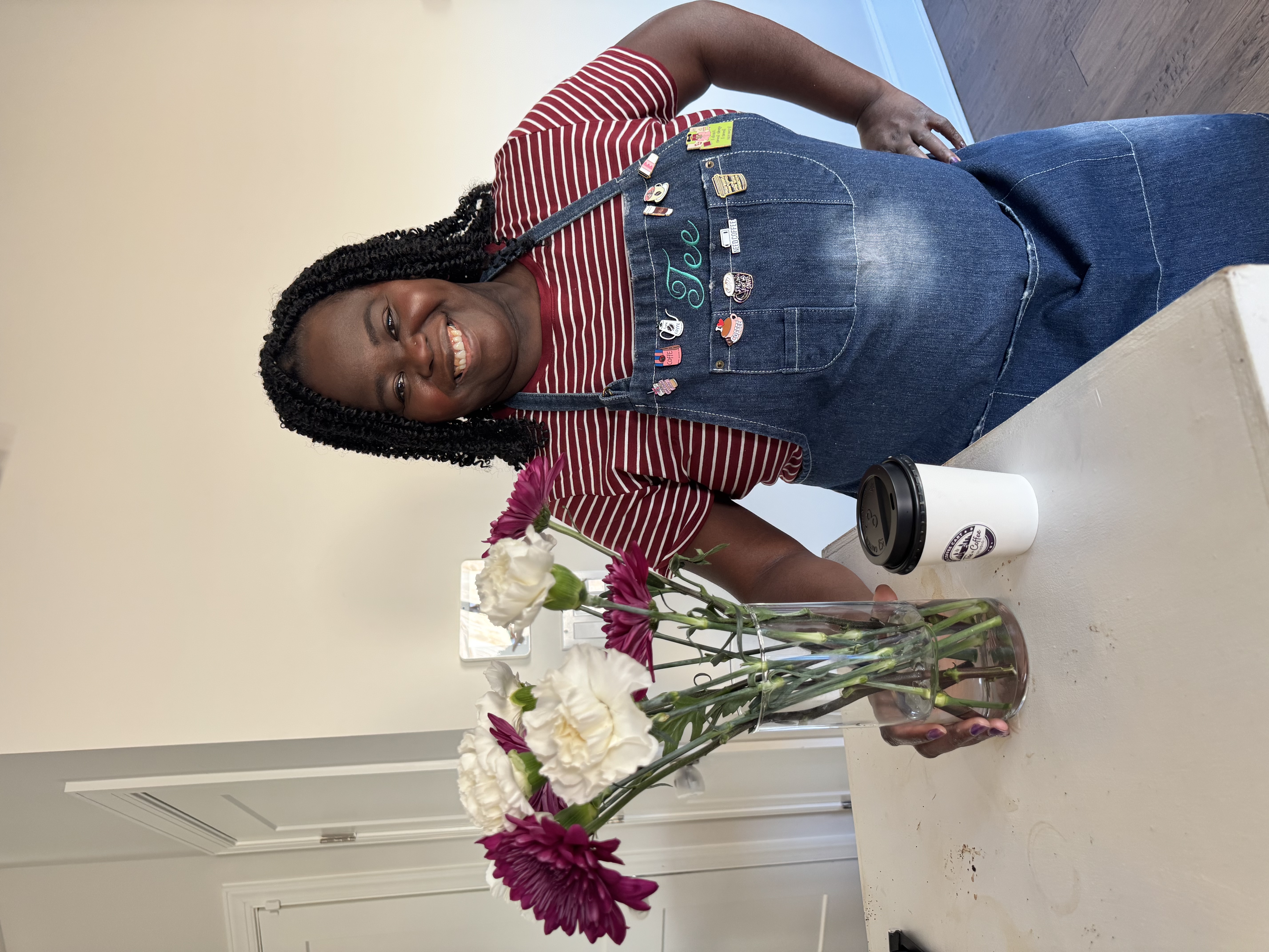 Tee George in signature denim Tee apron with fresh flowers and branded coffee cup at Atlanta event