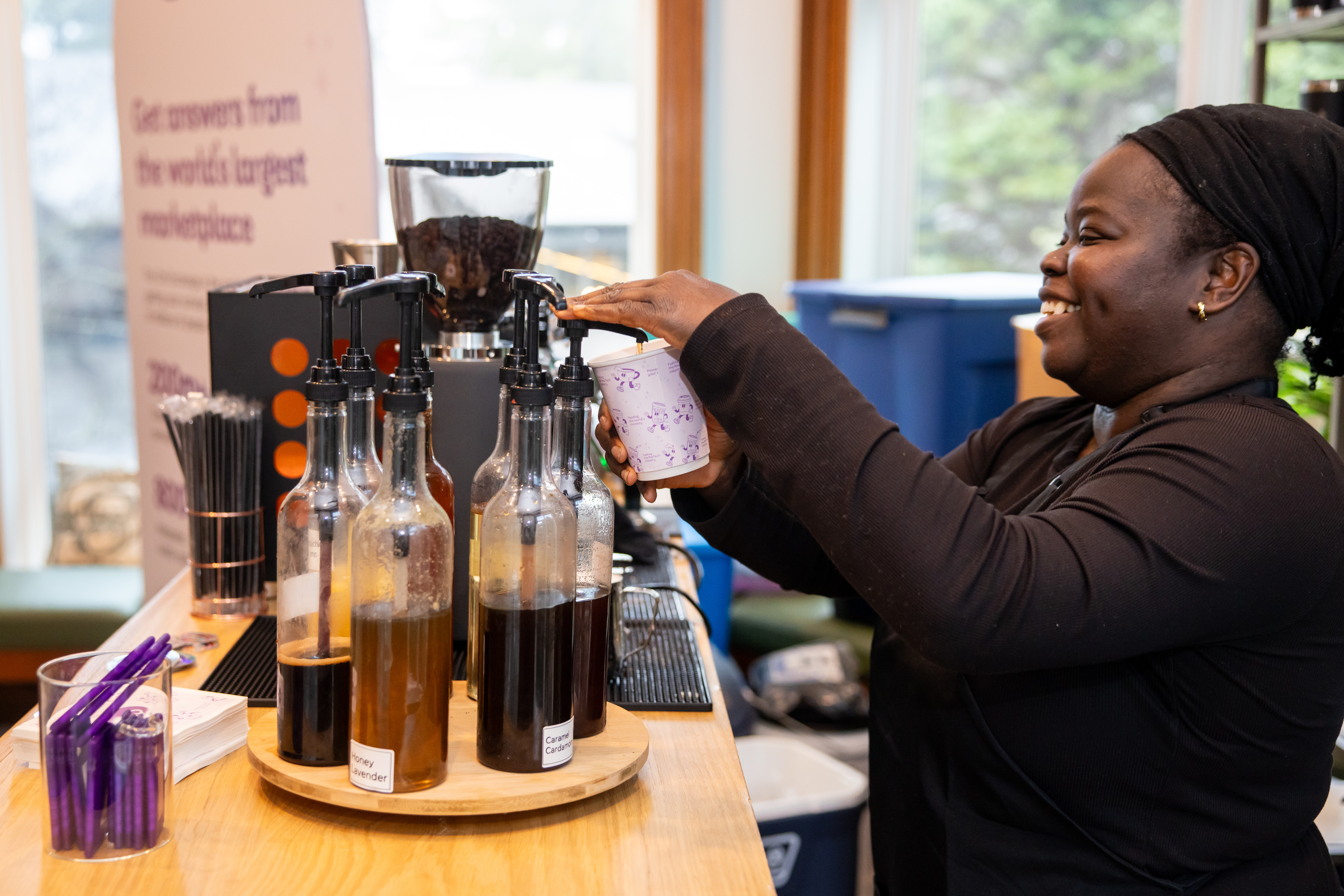 Tee George adding house-made specialty syrup to a branded cup at Atlanta corporate event — the detail that makes the drink