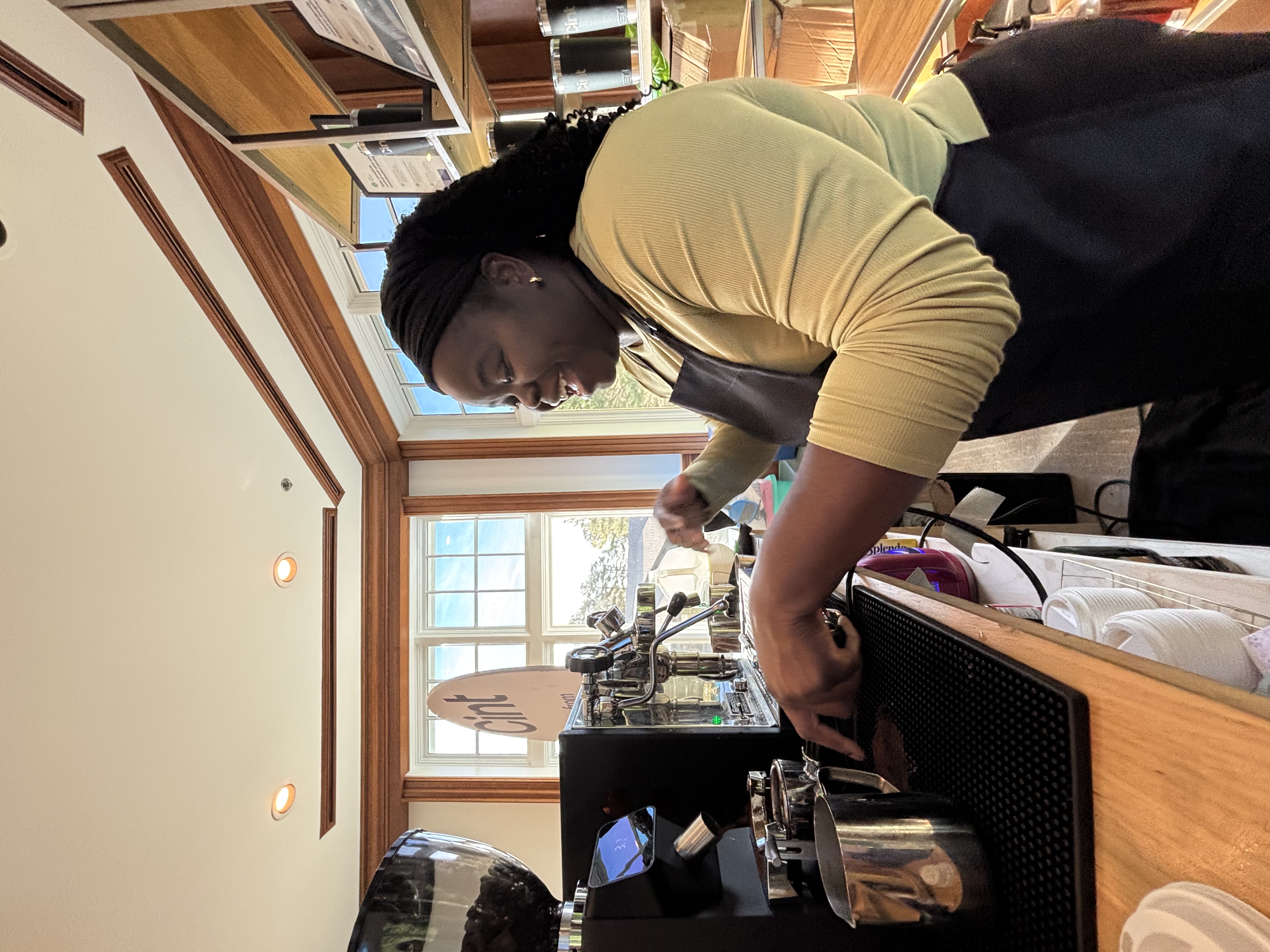 Tee George profile shot working the espresso machine at Atlanta corporate conference event in bay window setting
