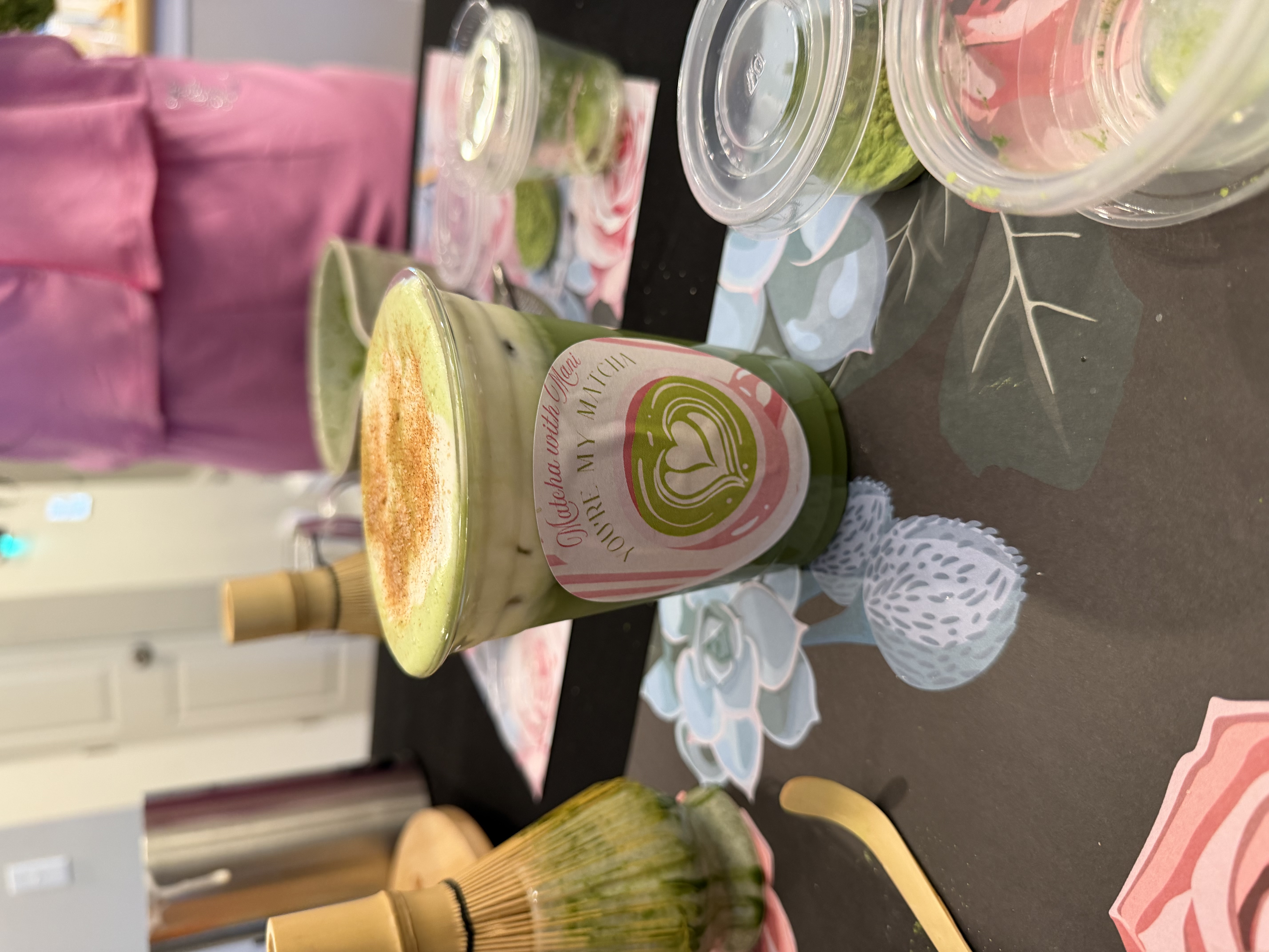 Finished matcha latte with cold foam and cinnamon dusting in branded Tee Coffee Studio cup