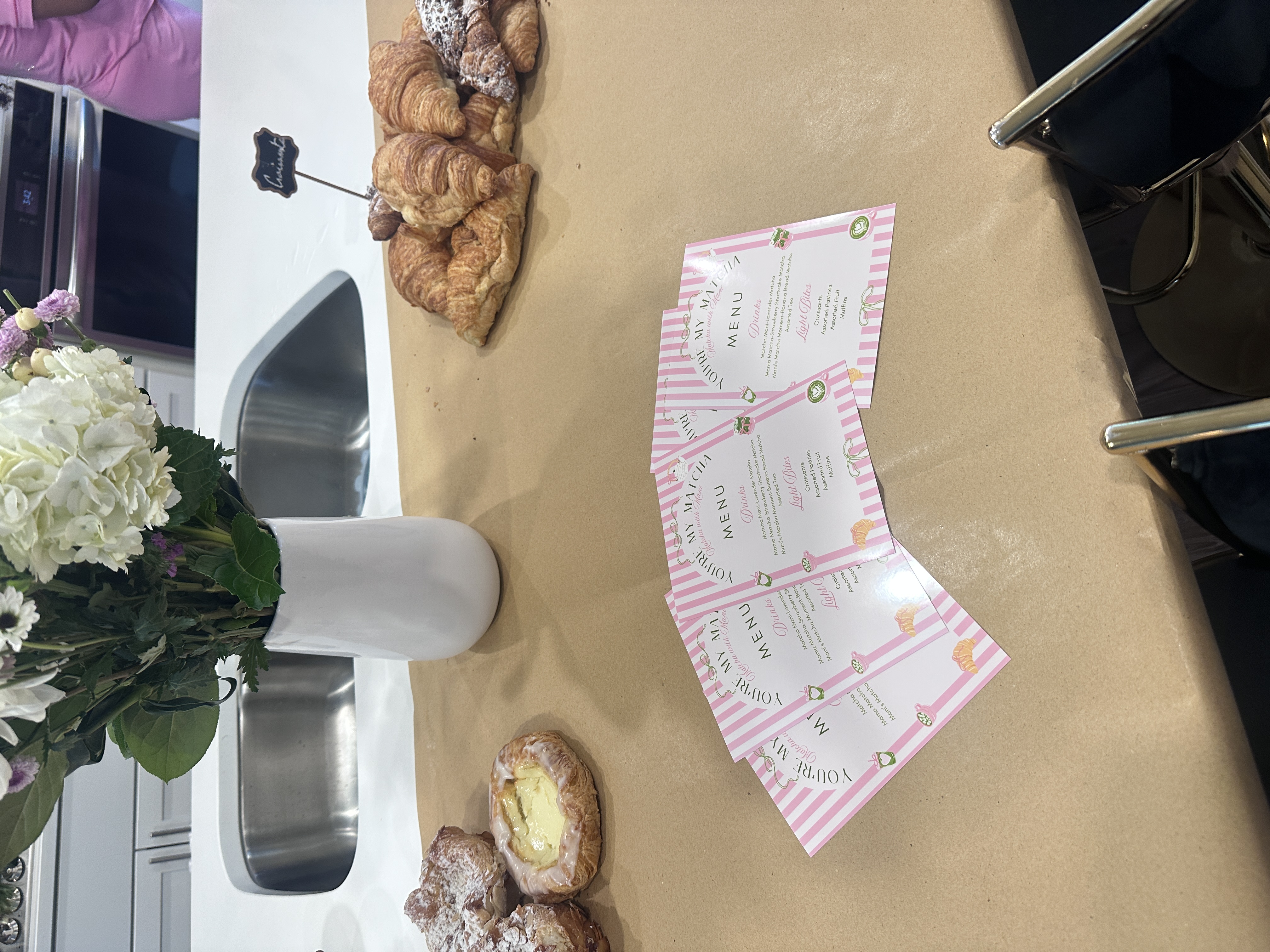 You're My Matcha event menu cards displayed with croissants and pastries at Atlanta matcha party