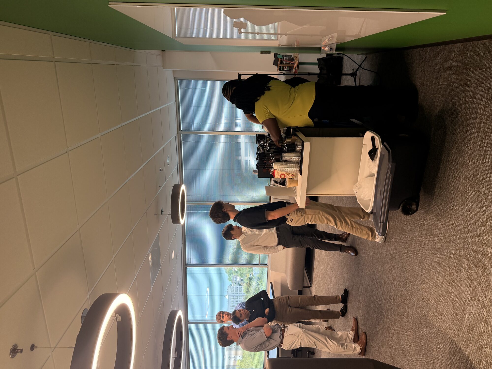 Barista handing off an iced coffee to a corporate guest at a Tee Coffee Studio office event